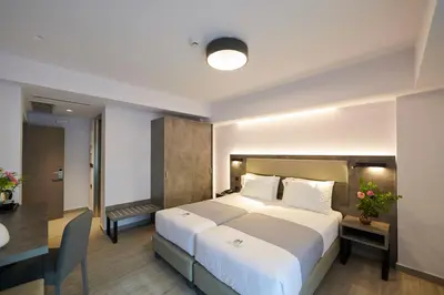 a hotel room with a large bed and a desk at Meni Hotel & Apartments UNDER NEW MANAGEMENT in Athens