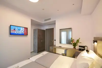 a bedroom with a bed and a desk and a tv at Meni Hotel & Apartments UNDER NEW MANAGEMENT in Athens