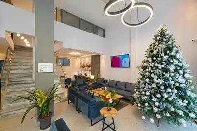 a christmas tree in a living room with a blue couch at Meni Hotel & Apartments UNDER NEW MANAGEMENT in Athens