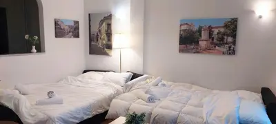 a large bed with white sheets in a room at Comfortable apartment in Acropolis in Athens