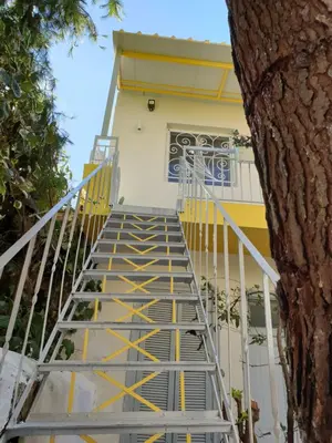a stairway leading up to a building with a yellow door at Cozy Studio 4U Gazi - Center Athens in Athens