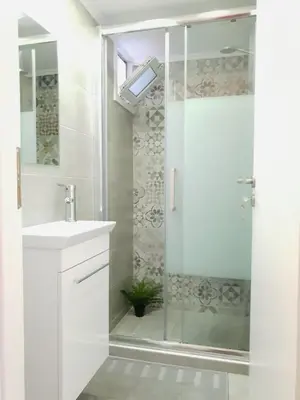 a white bathroom with a shower and a sink at Cozy Studio 4U Gazi - Center Athens in Athens