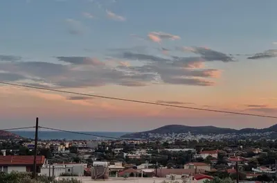 a view of a city at sunset at Thelfi Luxury studio in Attica - close to varkiza beach - Sea view in Vari