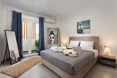 a bedroom with a bed with a laptop on it at The Aristotelian Suites by Athens Stay in Athens