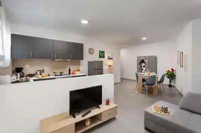 a living room with a couch and a tv and a kitchen at The Aristotelian Suites by Athens Stay in Athens
