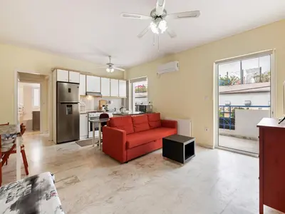 a living room with a red couch and a kitchen at Apartment in Piraeus near Athens Riviera in Athens