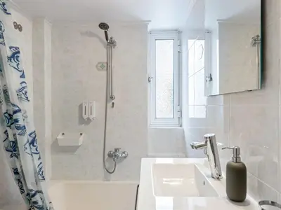 a white bathroom with a sink and a shower at Apartment in Piraeus near Athens Riviera in Athens