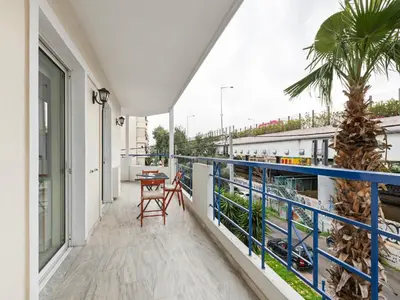 a balcony with a table and a palm tree at Apartment in Piraeus near Athens Riviera in Athens