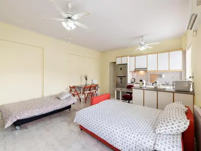 a living room with two beds and a kitchen at Apartment in Piraeus near Athens Riviera in Athens