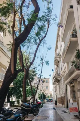 a row of motorcycles parked on a street next to buildings at API Projects Athens - Parliament Apartment in Athens