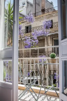 an open window with purple flowers on a balcony at API Projects Athens - Parliament Apartment in Athens