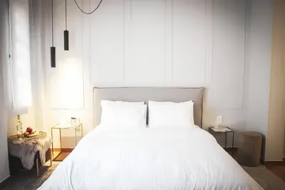 a bedroom with a large white bed with white sheets at API Projects Athens - Parliament Apartment in Athens