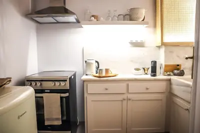 a small kitchen with a stove and white cabinets at API Projects Athens - Parliament Apartment in Athens