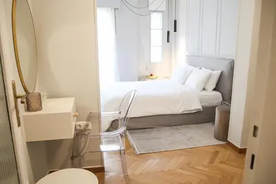 a bedroom with a bed with a mirror and a chair at API Projects Athens - Parliament Apartment in Athens