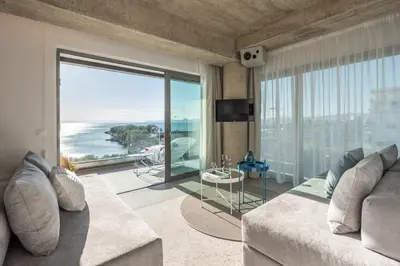 a living room with a couch and a view of the ocean at Urban Suites in Athens