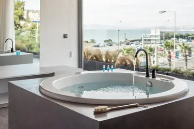 a bathroom with a bath tub with a large window at Urban Suites in Athens
