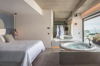 a bedroom with a tub next to a bed at Urban Suites in Athens