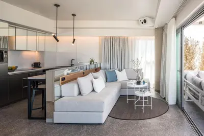 a living room with a white couch and a kitchen at Urban Suites in Athens