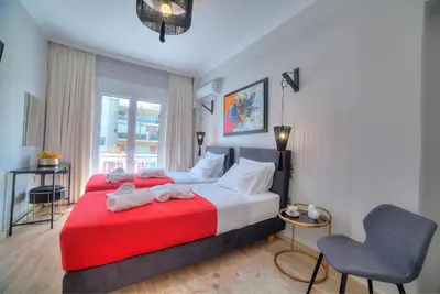 a bedroom with two beds and a chair at Amazing apartment in Glyfada center in Athens