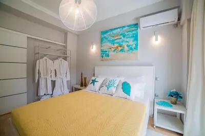 a bedroom with a bed with a yellow bedspread at Amazing apartment in Glyfada center in Athens