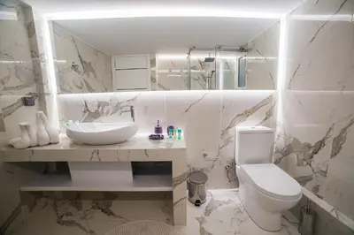 a white bathroom with a sink and a toilet at Amazing apartment in Glyfada center in Athens