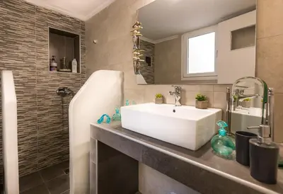 a bathroom with a white sink and a shower at Hidden Paradise in Piraeus