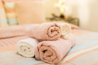 a pile of towels sitting on top of a bed at Hidden Paradise in Piraeus
