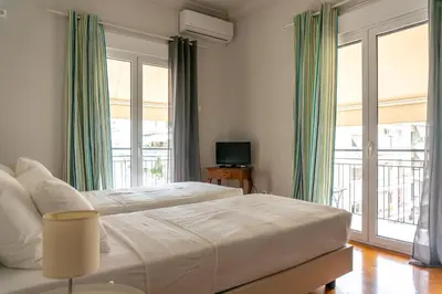 a bedroom with a large bed with green curtains at Acropolis Now! 2BR in central Athens in Athens