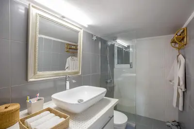 a bathroom with a sink and a glass shower at Acropolis Now! 2BR in central Athens in Athens