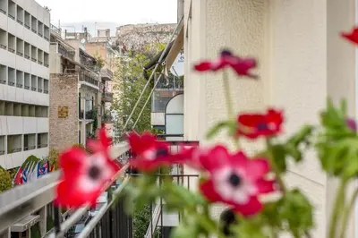 a group of red flowers on a balcony at Acropolis Now! 2BR in central Athens in Athens