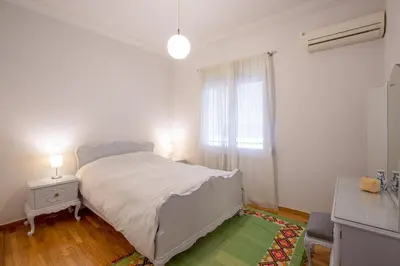a white bedroom with a bed and a window at Acropolis Now! 2BR in central Athens in Athens