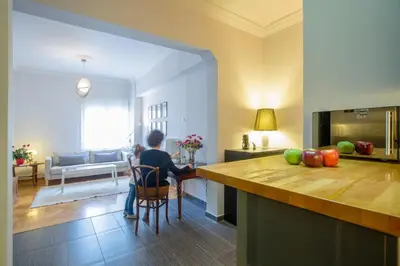 a person sitting in a chair in a kitchen at Acropolis Now! 2BR in central Athens in Athens