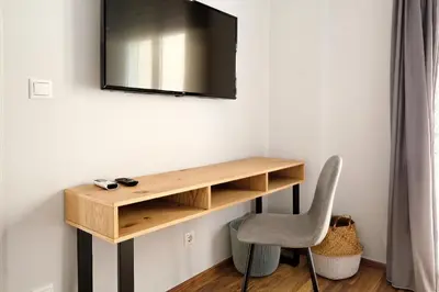 a room with a desk and a television on a wall at Poseidon Residence in Athens