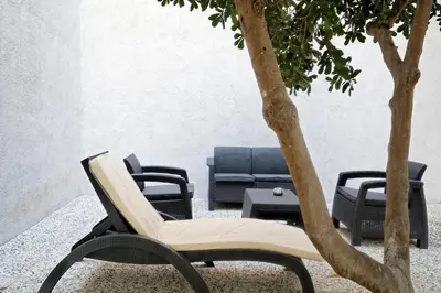 a chair and a table and a tree at Poseidon Residence in Athens