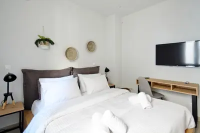 a bedroom with a bed and a flat screen tv at Poseidon Residence in Athens