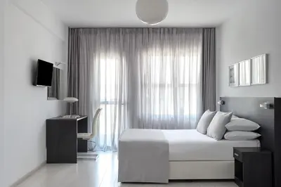 a white bedroom with a bed and a window at Boss Boutique Athens by Prima Hotels in Athens