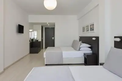 a hotel room with two beds and a couch at Boss Boutique Athens by Prima Hotels in Athens