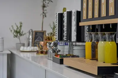 a bar with bottles of orange juice on a counter at Boss Boutique Athens by Prima Hotels in Athens