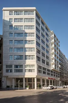 a large white building with cars parked in front of it at Boss Boutique Athens by Prima Hotels in Athens