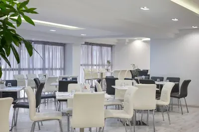a dining room with white tables and chairs at Boss Boutique Athens by Prima Hotels in Athens