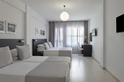 a hotel room with two beds and a couch at Boss Boutique Athens by Prima Hotels in Athens