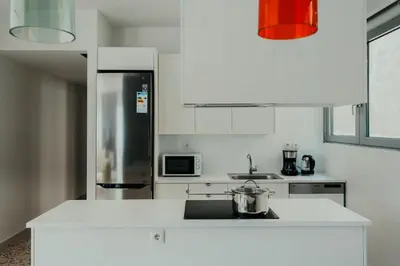 a white kitchen with a refrigerator and a sink at Stylish Suite, by MGM Residencies in Athens