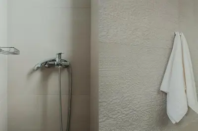 a bathroom with a shower with a white towel at Stylish Suite, by MGM Residencies in Athens