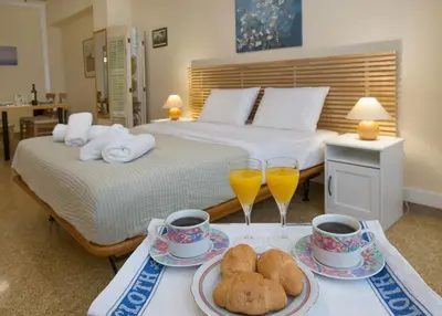 a hotel room with two beds and two glasses of orange juice at Central apartment on pedestrian street by GHH in Athens