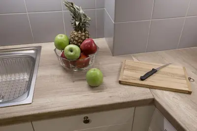 a bowl of fruit on a counter with a cutting board at Central apartment on pedestrian street by GHH in Athens