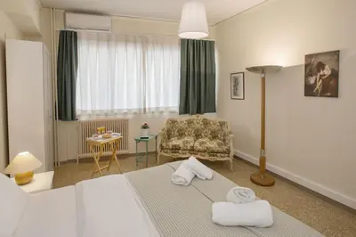 a hotel room with a bed and a chair at Central apartment on pedestrian street by GHH in Athens