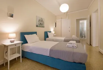 a bedroom with two beds and a table with a lamp at Central apartment on pedestrian street by GHH in Athens