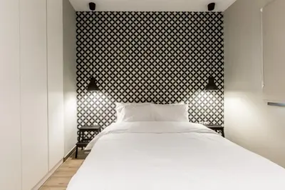 a bedroom with a white bed and a black wall at ATHENSIS Apartments in Central Athens in Athens