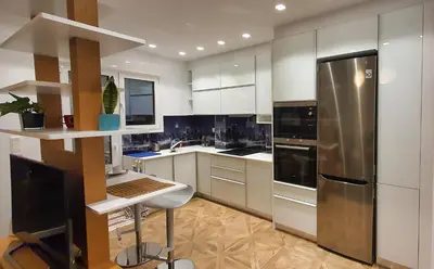 a kitchen with white cabinets and a stainless steel refrigerator at The Six Museums central Athens Stadium 4pers apart in Athens