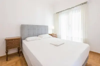 a bedroom with a large white bed and a window at Victoria Supreme Suite in Athens